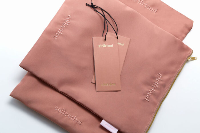 Pink reusable pouches from Girlfriend Collective, made with sustainable materials and featuring a branded hang tag.