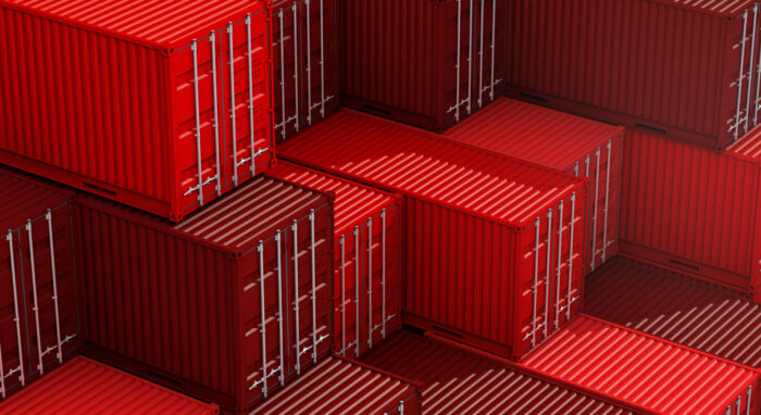 Image of red stack containers on a cargo freight ship, representing import-export industry.