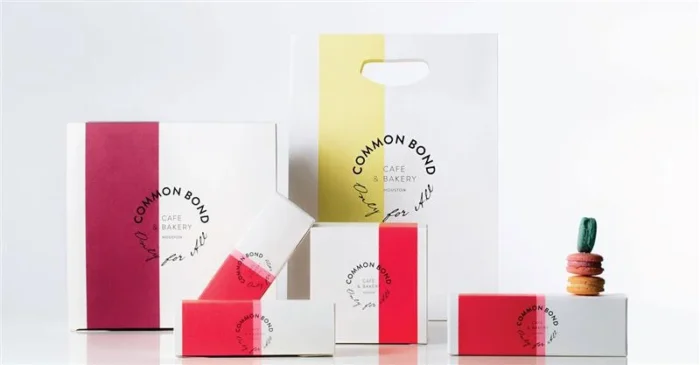 White bakery boxes and bags with bold red and yellow accents from Common Bond Café & Bakery in Houston.