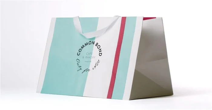 Large teal and red Common Bond paper bag with handles, designed for café and bakery takeout.