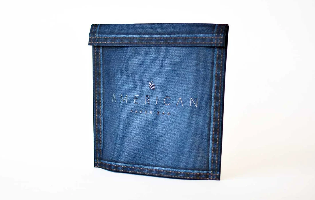 Blue denim-textured paper mailer featuring logo, illustrating creative ecommerce packaging design.