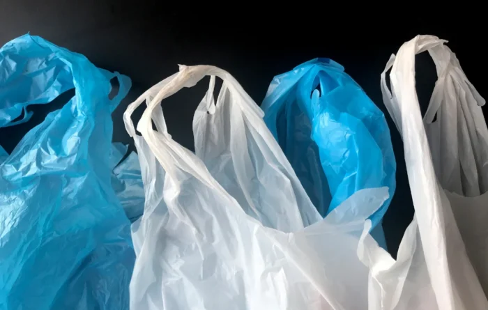 White and blue single-use plastic retail bags stacked together.